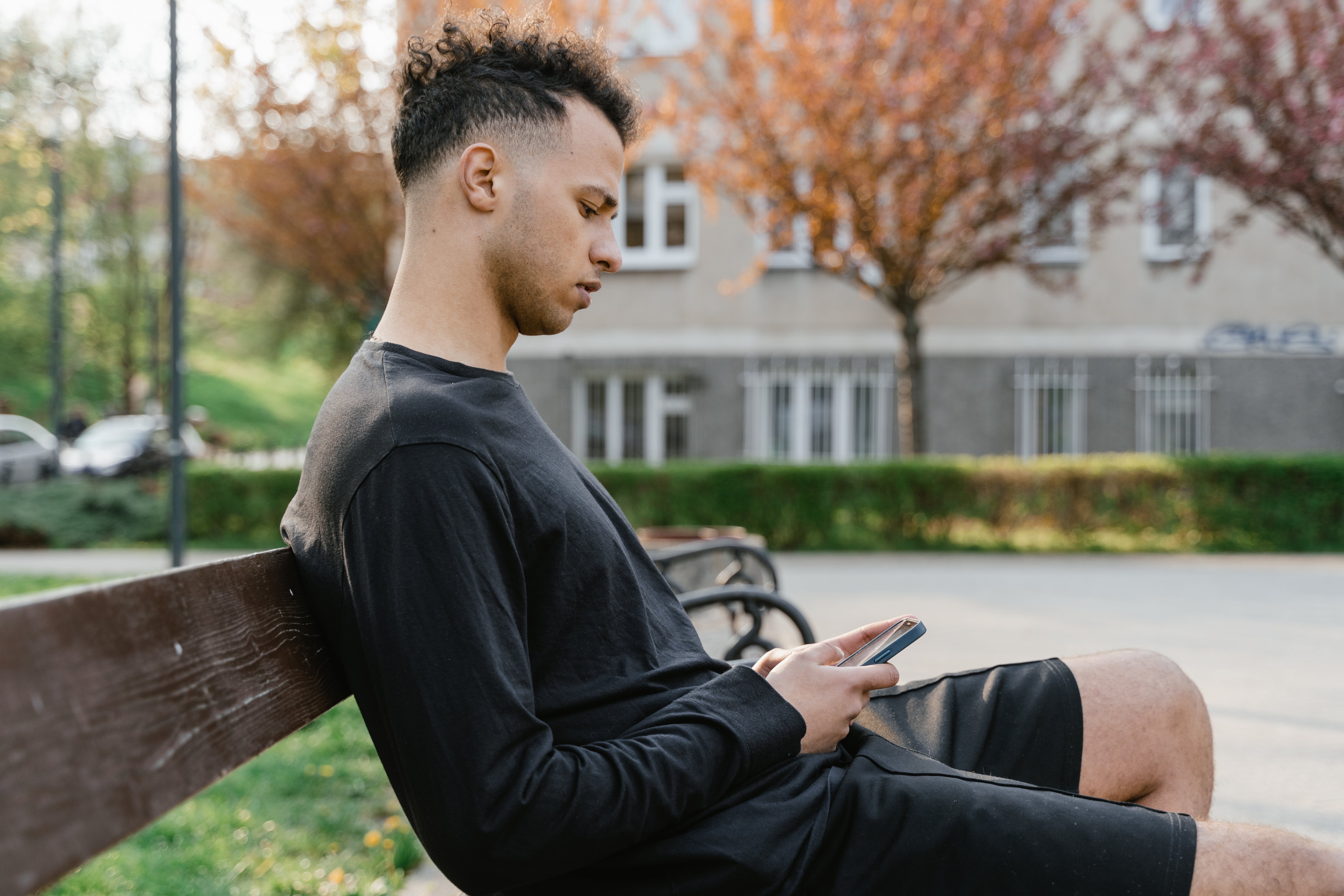 A man scrolling his phone while sitting.